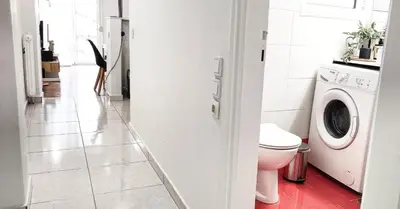 a bathroom with a toilet and a washing machine at Διαμέρισμα στο Θησείο in Athens