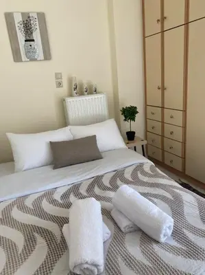 a bedroom with a bed with two towels on it at Daphnes Crown in Athens