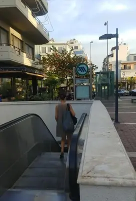 a woman walking down an escalator in a city at Daphnes Crown in Athens