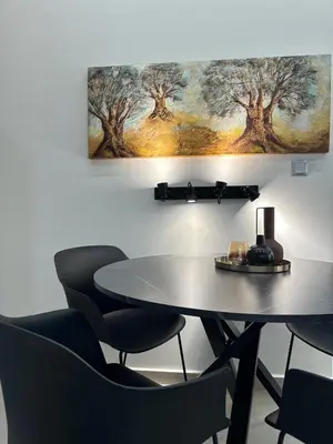 a table and chairs in a room with a painting on the wall at Estia Athens Apartment in Athens