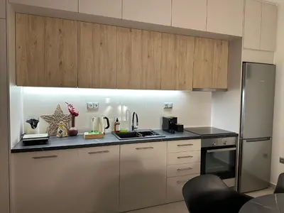 a kitchen with white cabinets and stainless steel appliances at Estia Athens Apartment in Athens