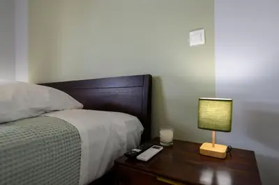 a bedroom with a bed and a lamp on a night stand at Luxury 2 bed Urban Oasis in the Heart of Athens in Athens