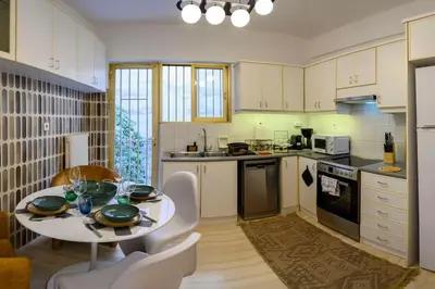 a kitchen with a table and chairs in a kitchen at Luxury 2 bed Urban Oasis in the Heart of Athens in Athens