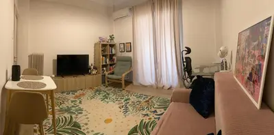 a living room with a couch and a television at Veli's Apartment in Athens