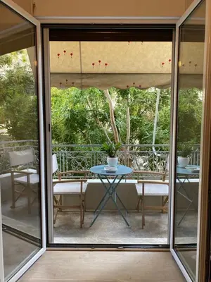 a glass door with a table and chairs on a patio at Veli's Apartment in Athens