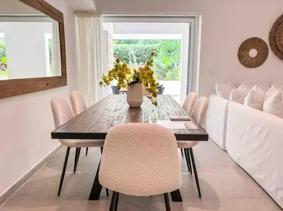 a dining room table with chairs and a vase of flowers at Elegant Flat in Glyfada Center in Athens
