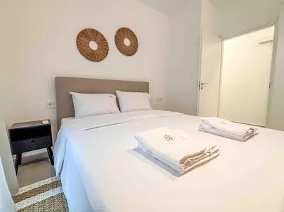 a bedroom with a white bed with two towels on it at Elegant Flat in Glyfada Center in Athens