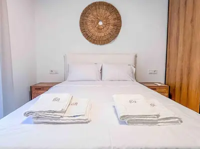 a white bed with towels on top of it at Elegant Flat in Glyfada Center in Athens