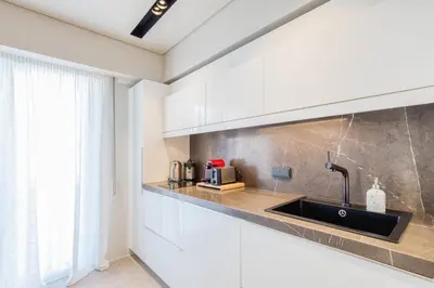 a kitchen with white cabinets and a sink at Syntagma Luxe Loft in Athens