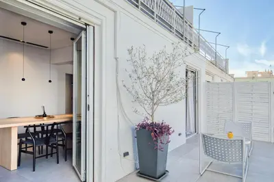 a balcony with a table and chairs and a vase with a plant at Syntagma Luxe Loft in Athens