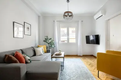 a living room with a couch and a tv at Dew 1-Bedroom Apartment in Athens in Athens