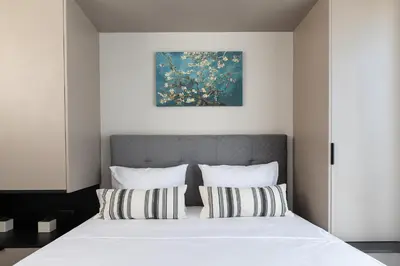 a bedroom with a large white bed with striped pillows at Central apartment 5min from Omonoia Subway Station in Athens