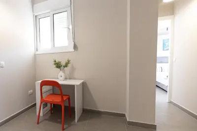 a red chair sits next to a table in a room at Central apartment 5min from Omonoia Subway Station in Athens
