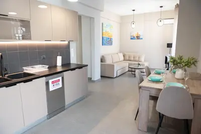a kitchen and living room with a table and a couch at Central apartment 5min from Omonoia Subway Station in Athens