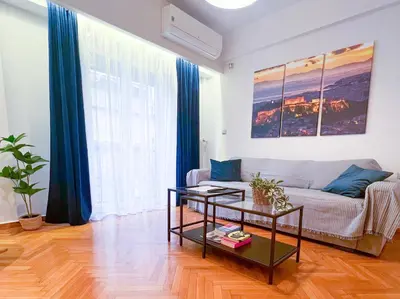 a living room with a couch and a table at 2 Bedroom Apartment Athens - Kallimarmaro in Athens