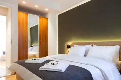 a bedroom with a large bed with towels on it at 2 Bedroom Apartment Athens - Kallimarmaro in Athens