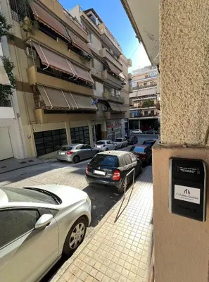 a parking meter on the side of a street with cars at 2 Bedroom Apartment Athens - Kallimarmaro in Athens