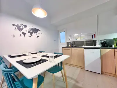 a kitchen with a white table and blue chairs at 2 Bedroom Apartment Athens - Kallimarmaro in Athens