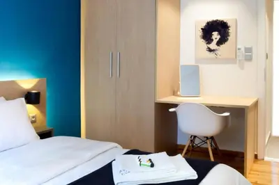 a bedroom with a bed and a desk and a chair at 2 Bedroom Apartment Athens - Kallimarmaro in Athens