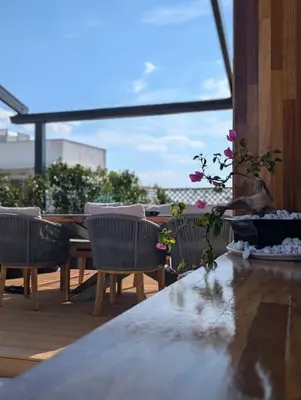 a table and chairs on a patio with a table and flowers at Loft with Panoramic View near the center of Athens in Athens