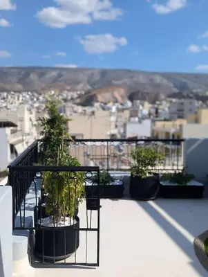 a balcony with potted plants on top of a building at Loft with Panoramic View near the center of Athens in Athens