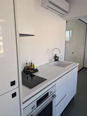 a white kitchen with a sink and a counter at Loft with Panoramic View near the center of Athens in Athens
