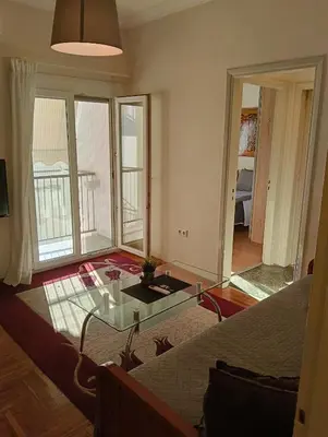 a living room with a glass table and a couch at Athens Apartment in Athens