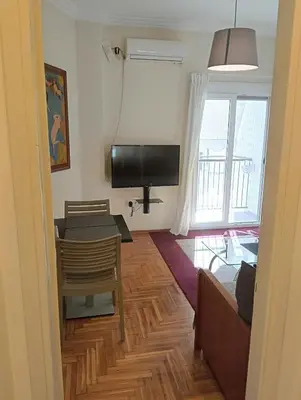 a living room with a television and a table and a couch at Athens Apartment in Athens