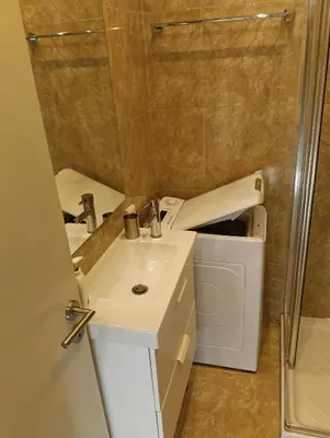a bathroom with a sink and a washing machine at Athens Apartment in Athens