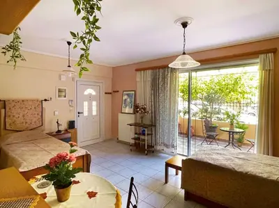 a bedroom with a bed and a living room with a table at Cosy Apartment with Garden 5 min from metro in Athens