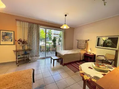 a living room with a bed and a table at Cosy Apartment with Garden 5 min from metro in Athens