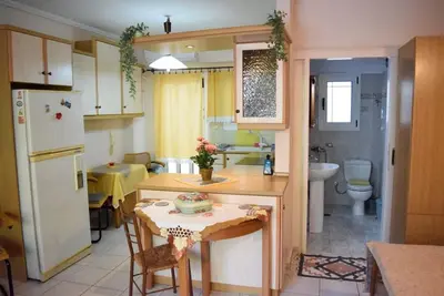 a kitchen with a small table and a refrigerator at Cosy Apartment with Garden 5 min from metro in Athens