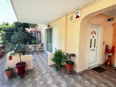 a courtyard with potted plants and a white door at Cosy Apartment with Garden 5 min from metro in Athens