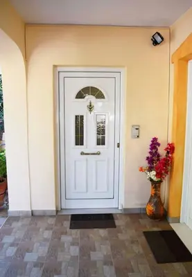 a white door with a vase of flowers next to it at Cosy Apartment with Garden 5 min from metro in Athens