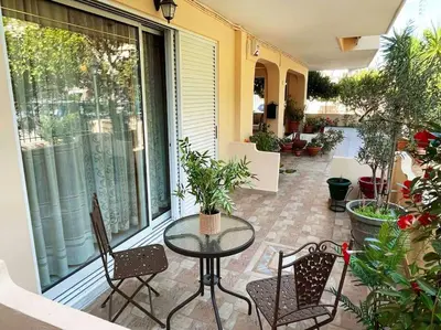a patio with a glass table and chairs on a patio at Cosy Apartment with Garden 5 min from metro in Athens