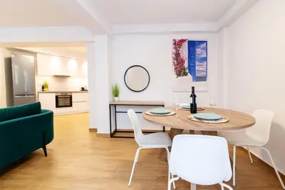 a dining room with a table and white chairs at Lighthouse Kipseli in Athens