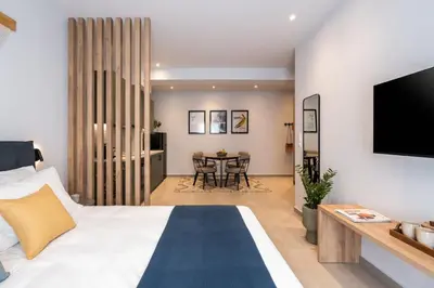 a bedroom with a large bed and a dining room at PAME Apartments Athens in Athens