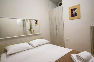 a bedroom with a white bed with a large mirror at Athenian Artistic Apt Lycabettus View in Athens