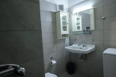 a bathroom with a sink and a mirror at Athenian Artistic Apt Lycabettus View in Athens