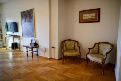 a living room with two chairs and a television at Athenian Artistic Apt Lycabettus View in Athens