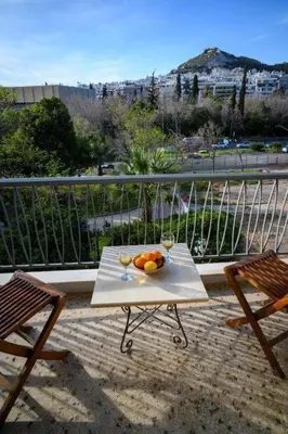 a table with a bowl of fruit on a balcony at Athenian Artistic Apt Lycabettus View in Athens