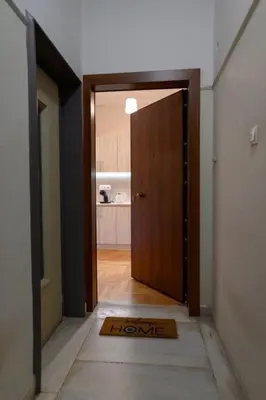 an open door to a room with a door mat at Athenian Artistic Apt Lycabettus View in Athens