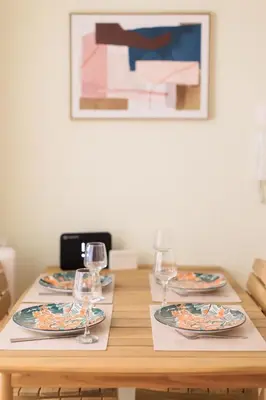 a wooden table with plates and wine glasses on it at AIOLOS elegant escapes kolonaki in Athens