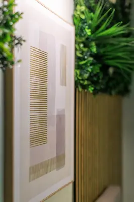 a painting on a wall with two potted plants at AIOLOS elegant escapes kolonaki in Athens