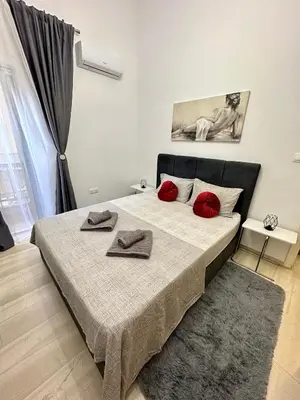 a bedroom with a bed with red pillows on it at Arkadia`Kalithea in Athens