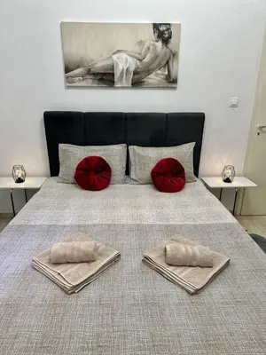 a large bed with two red pillows on it at Arkadia`Kalithea in Athens