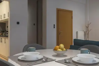 a table with bowls of fruit on top of it at Modern Ilisian Apartment in Athens