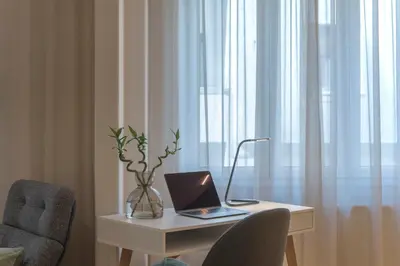 a desk with a laptop on it next to a chair at Modern Ilisian Apartment in Athens
