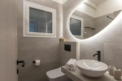 a bathroom with a sink and a mirror at Modern Ilisian Apartment in Athens
