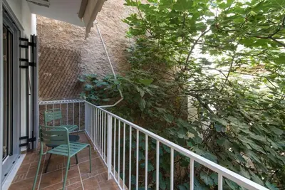 a balcony with a chair and a plant at Modern Ilisian Apartment in Athens